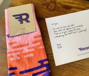 Custom branded socks from Reachdesk with a branded postcard with a handwritten note to a client