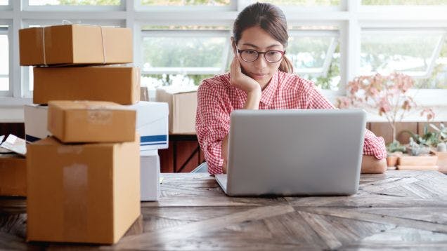 Woman sitting in her office in a nonprofit fulfilling orders from her online merchandise store