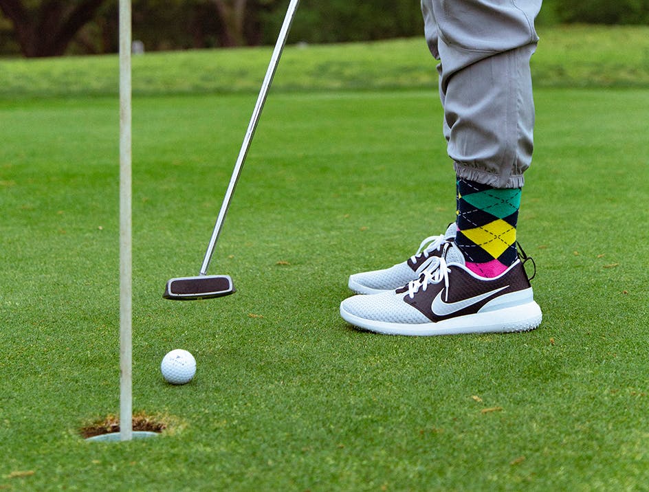 Person playing golf wearing patterned sport socks
