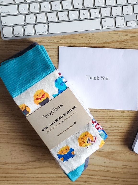 Employee Appreciation custom branded socks on an employee's desk with a thank you note