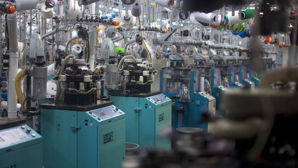 A row of sock knitting machines in Sock Club's custom sock manufacturing plant in North Carolina