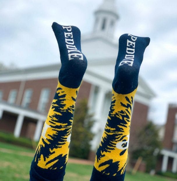 Custom socks for The Peddie School with a tie dye design in front of a school building