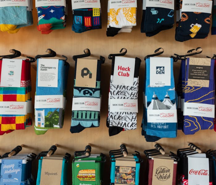 past clients of Sock Club for custom socks with logos hanging on wall