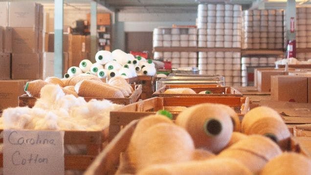 Sock Club's cotton spinning facility showing cotton in various stages of processing, from raw to yarn