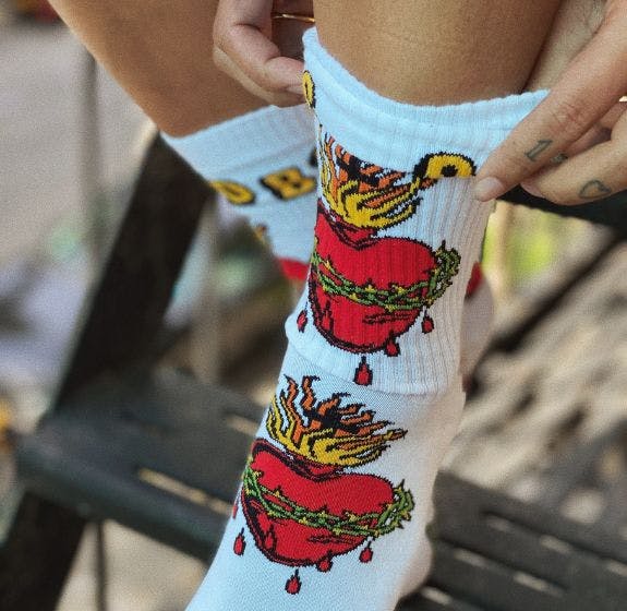 Custom socks for the Old Bones Society E-Commerce store featuring in intricate tattoo design of a heart with a crown of thorns from artist Matt Adamson
