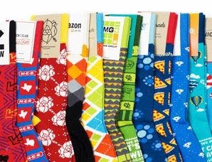 A rainbow of custom socks laid out showcasing different designs for Amazon, Microsoft, Sonic, and more