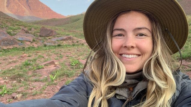 Selfie of custom sock designer Molly Lawrence on a desert hike in a hat
