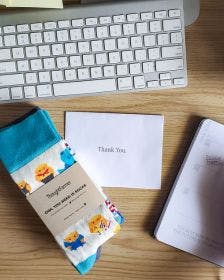 Employee Appreciation custom branded socks on an employee's desk with a thank you note