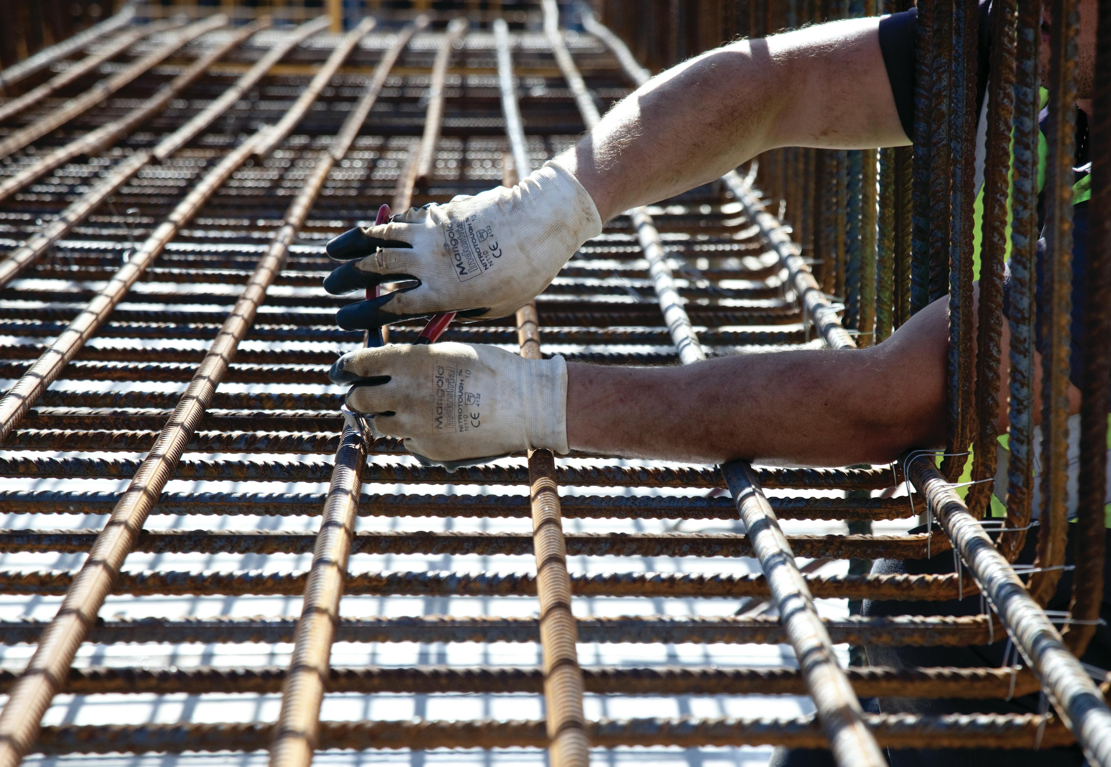 A worker fixing steel rods for ground works