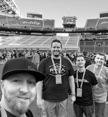 Alguns membros da equipe de desenvolvimento da SoCreate no campo do estádio do Seattle Seahawks.