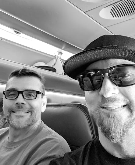 SoCreate CEO Justin en CTO Billy in een vliegtuig dat samen met de rest van het ontwikkelingsteam naar een ontwikkelaarsconferentie vliegt.