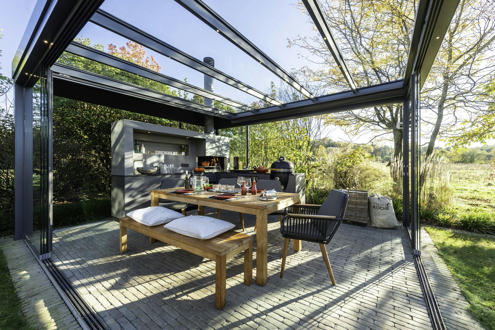 glass room with outdoor kitchen bbq area