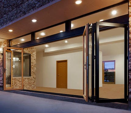 A home with wooden bi-folding doors opened out along the whole of a wall