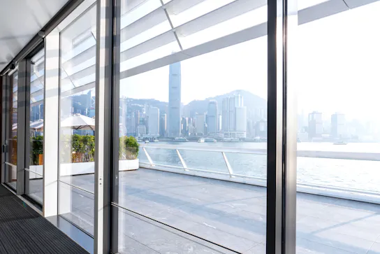 View through large sliding glass doors to river and cityscape outside.