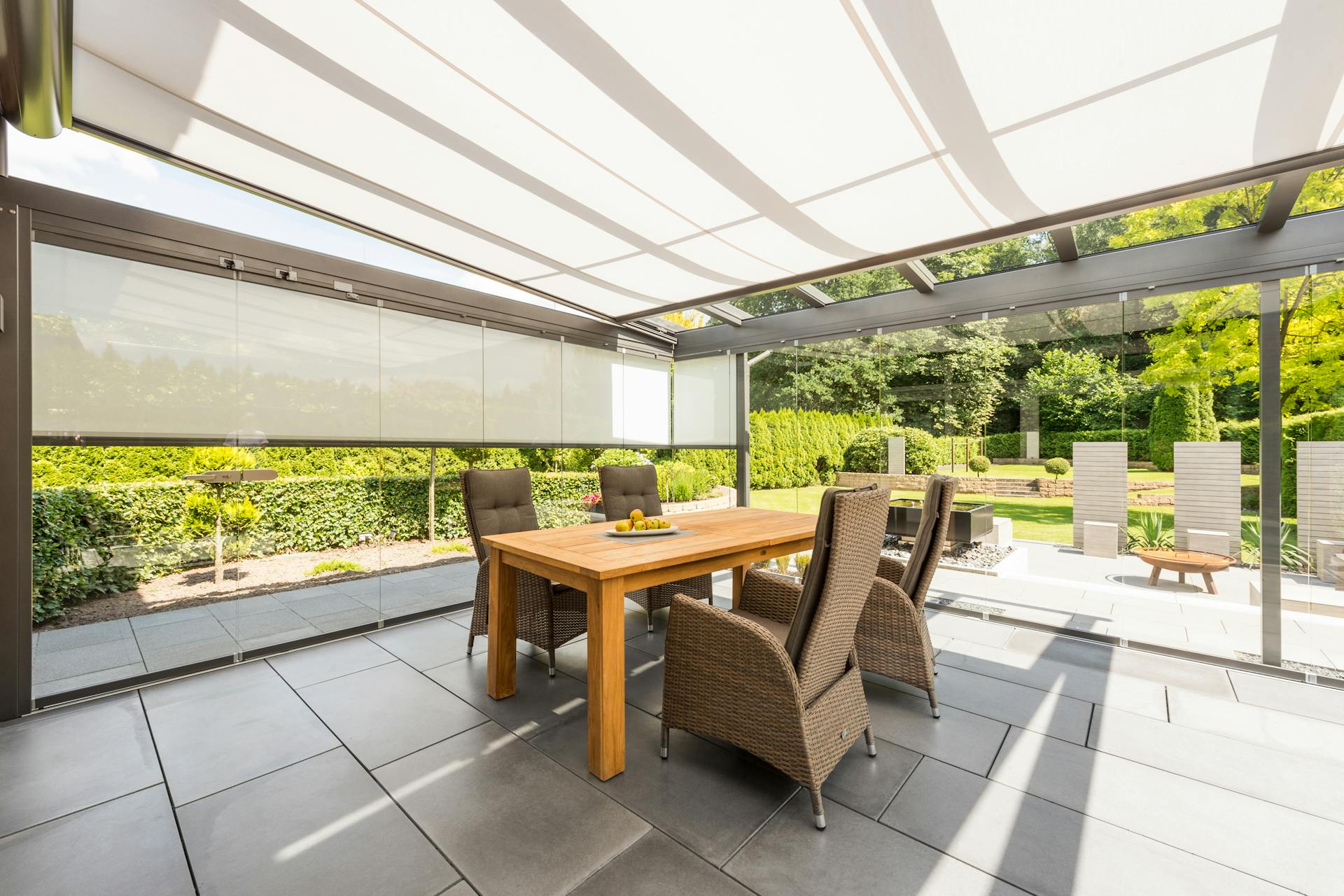Glass room with awning covers patio on summers day