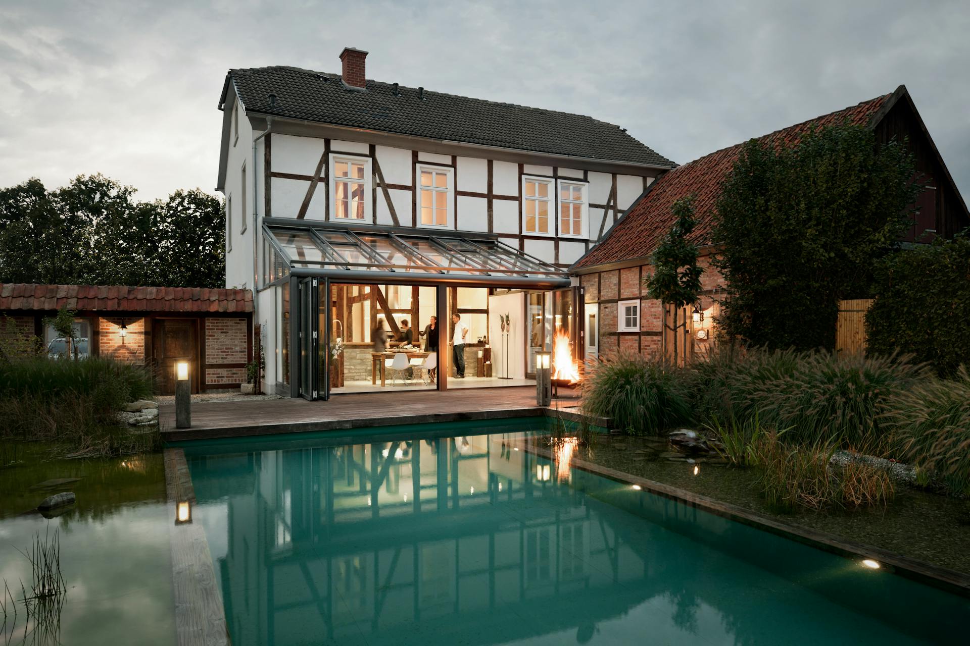 large white detached house with swimming pool and glass extension