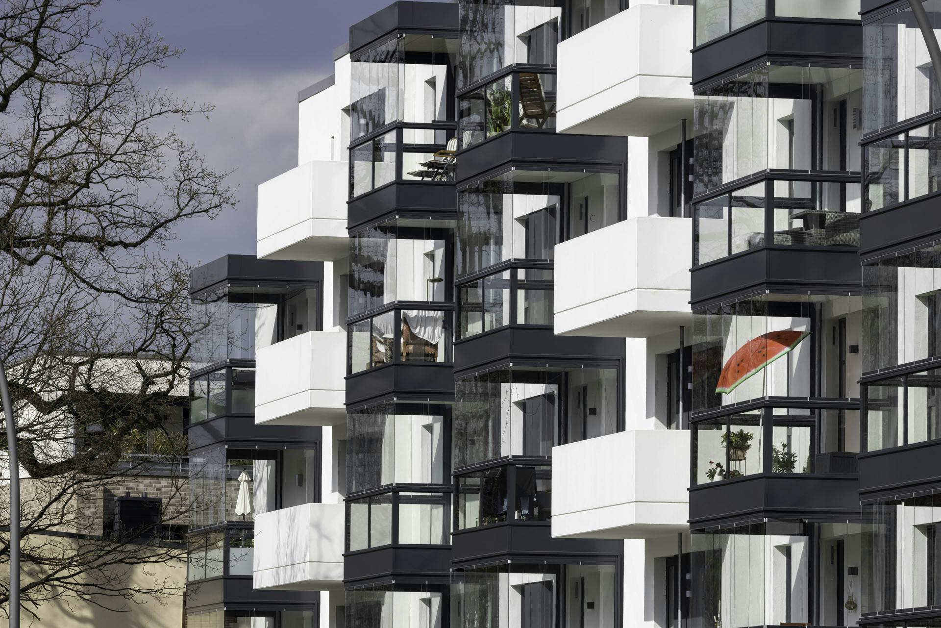 white apartment block with balconies and glazing