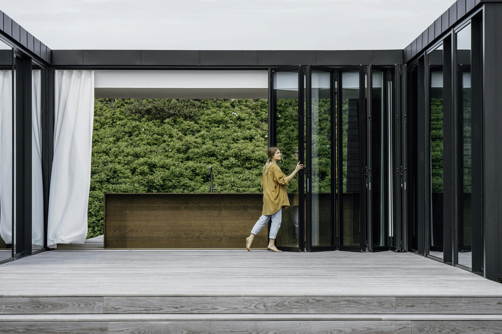 A person opening a Megaline bi-fold door with ease