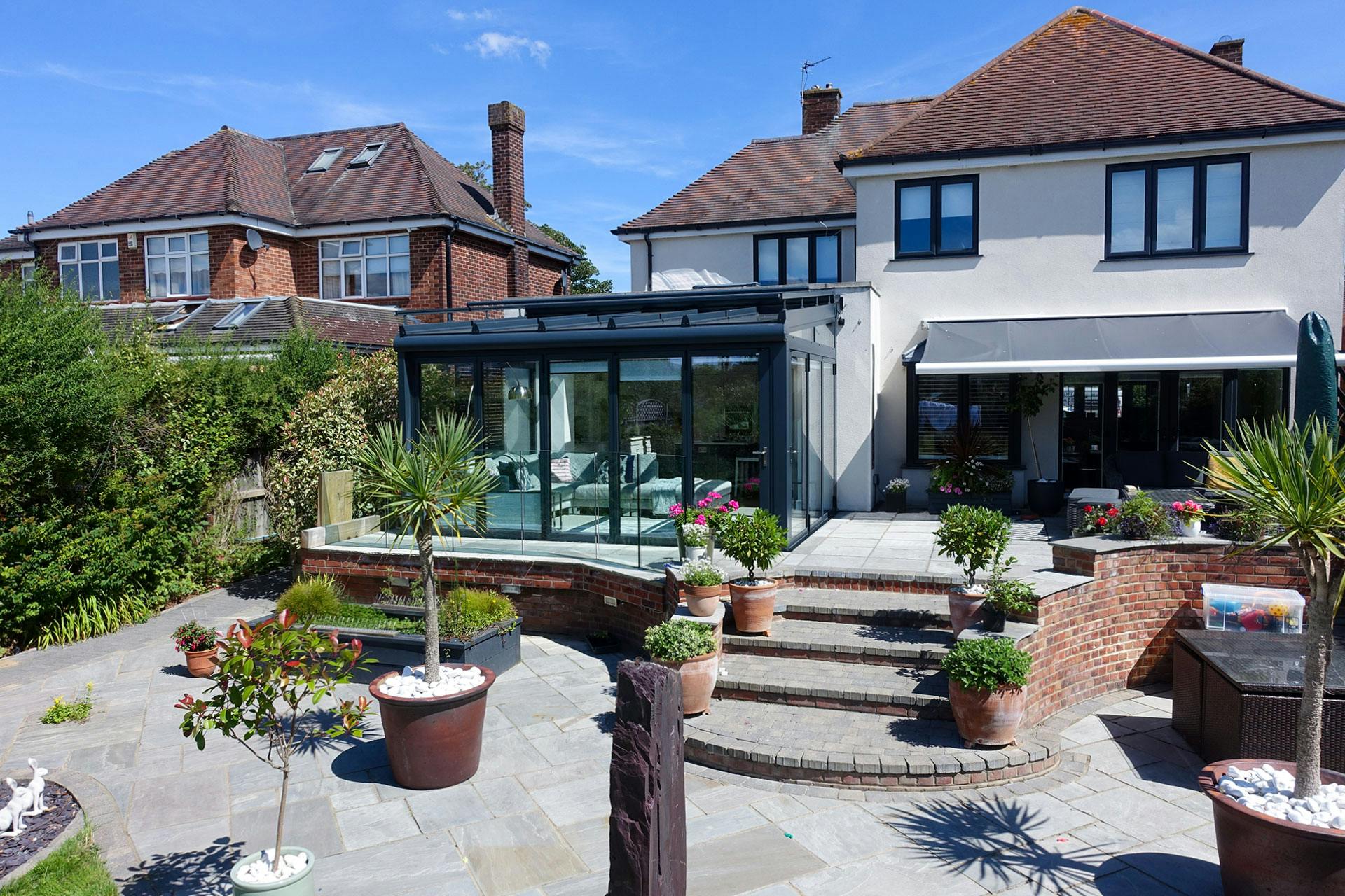 Glass room extension on white detached home with sea views