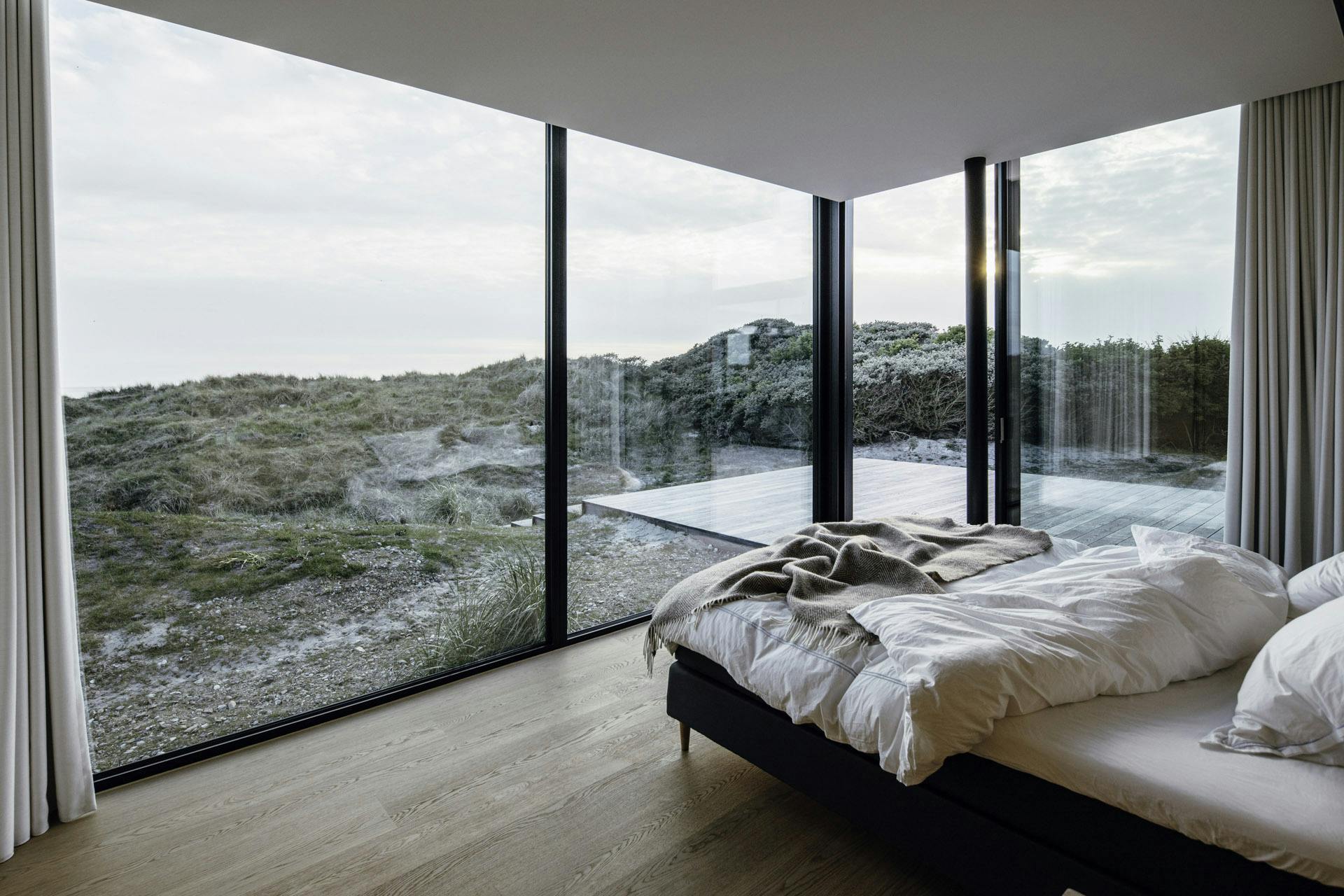 Bedroom with expansive outdoor views through large glazing