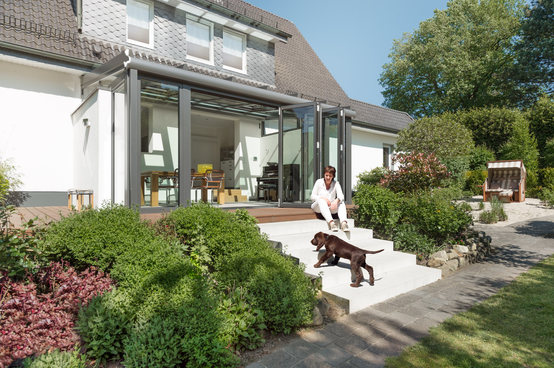 person with dog outside with bi-folding doors in the background