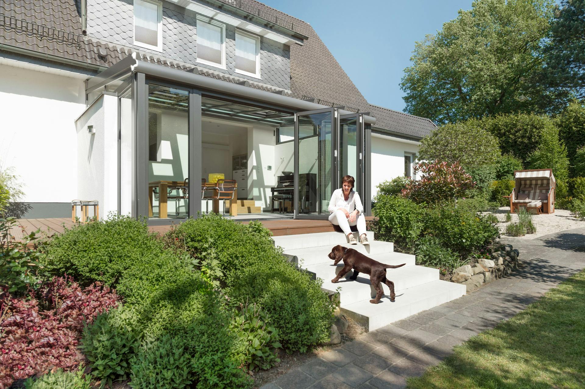 person with dog outside with bi-folding doors in the background