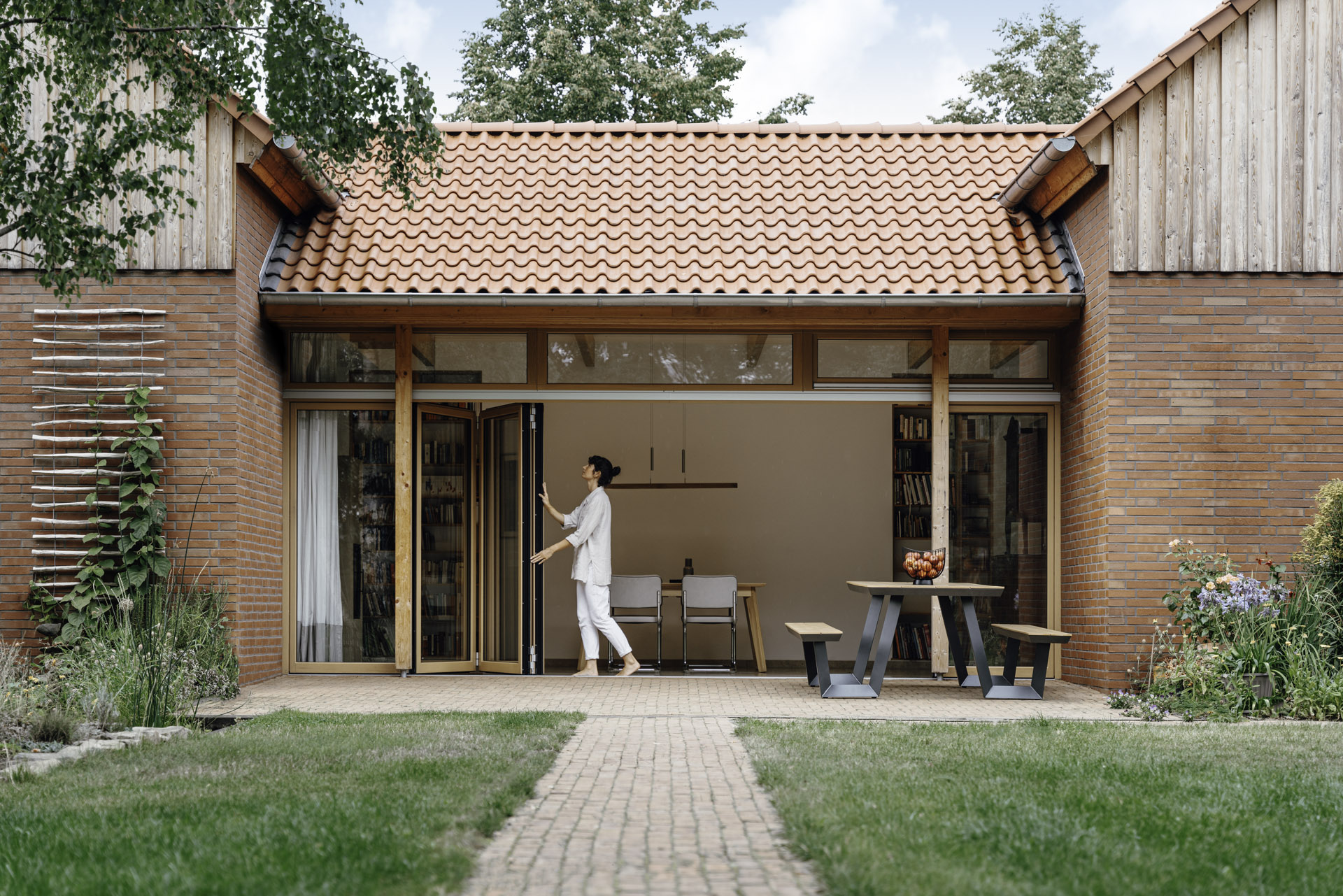 a lady opening a woodline bi-fold door
