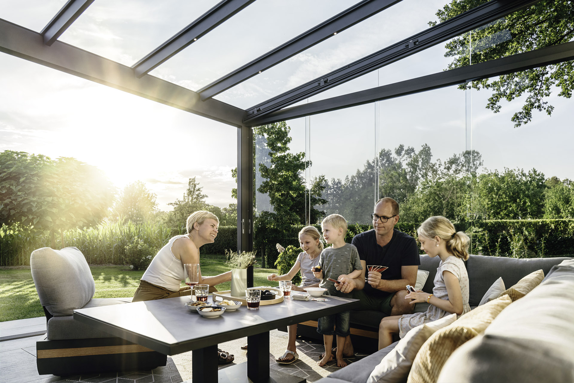 a family enjoying a meal in a Solarlux glass room