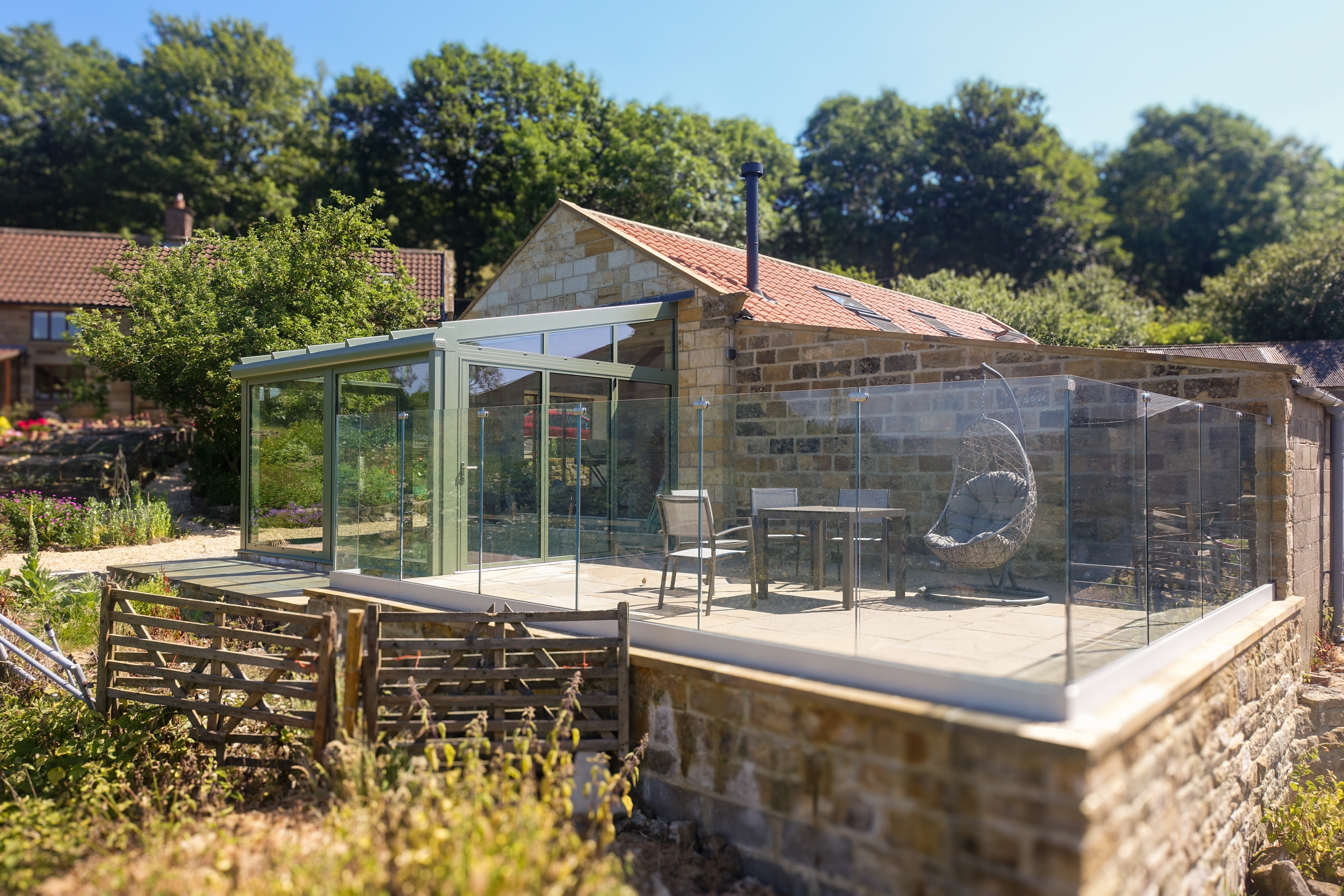 green frame glass home extension on yorkshire barn