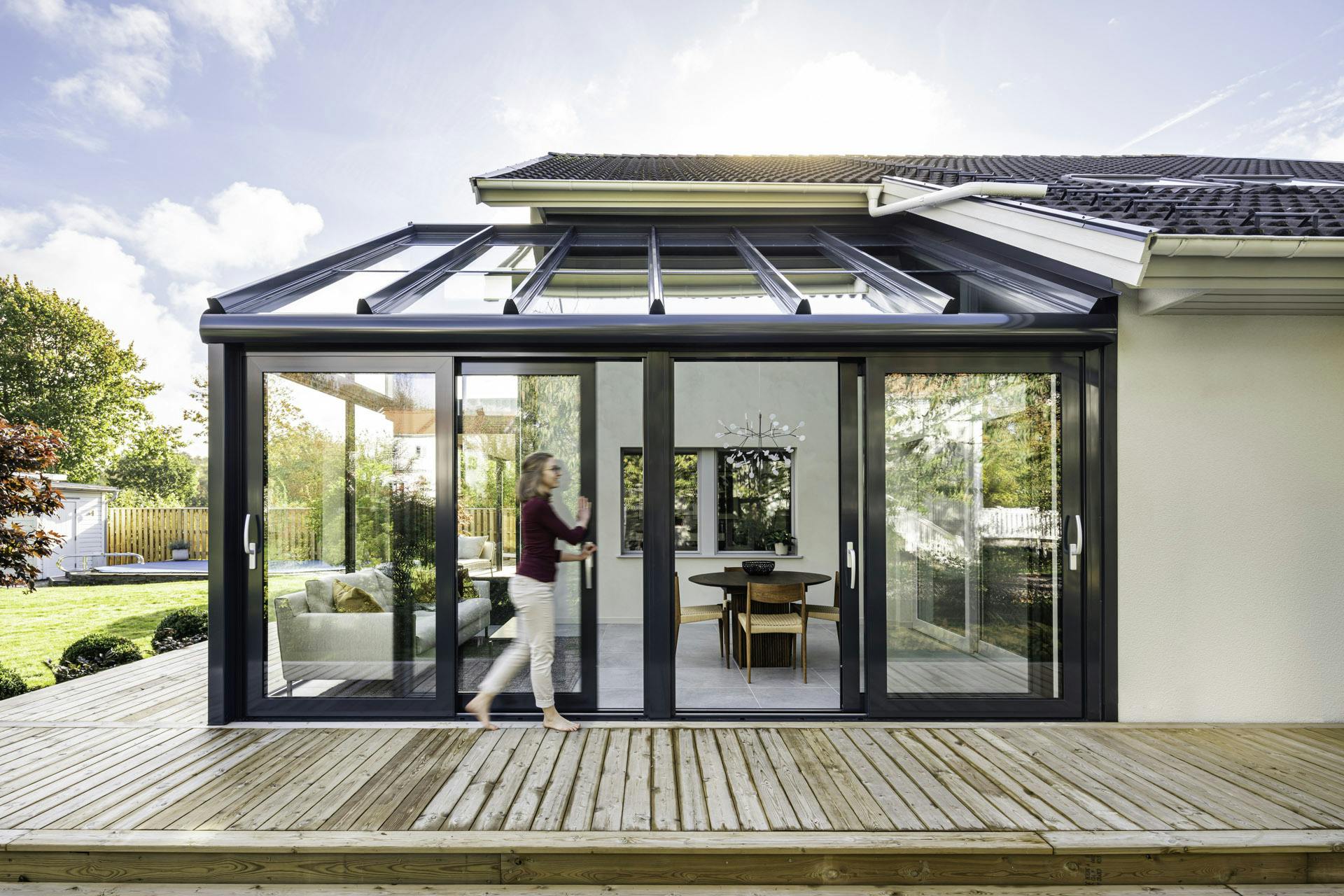 insulated conservatory with woman opening sliding doors