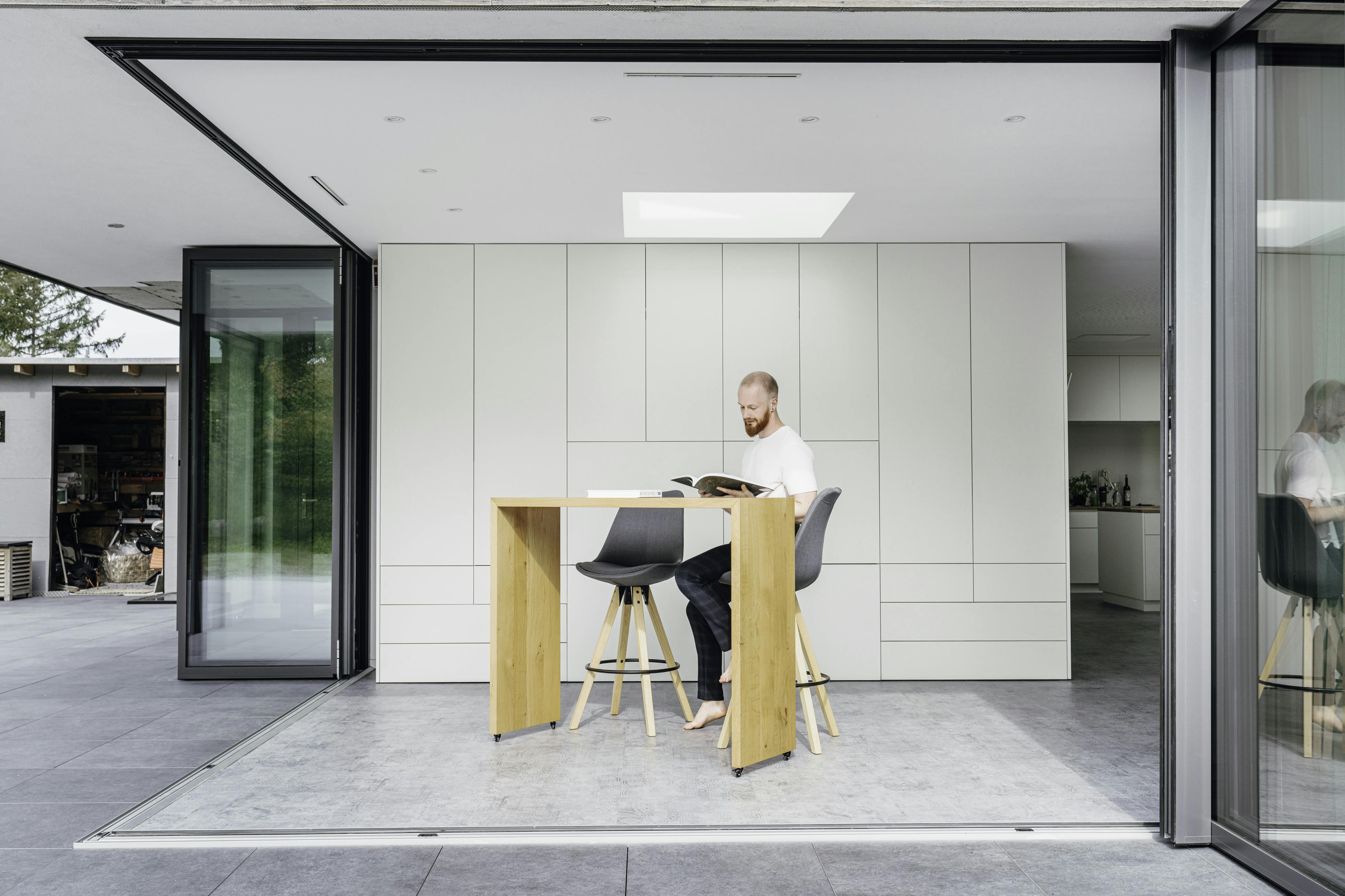 Open corner bi-fold doors in modern apartment with biophilic architecture