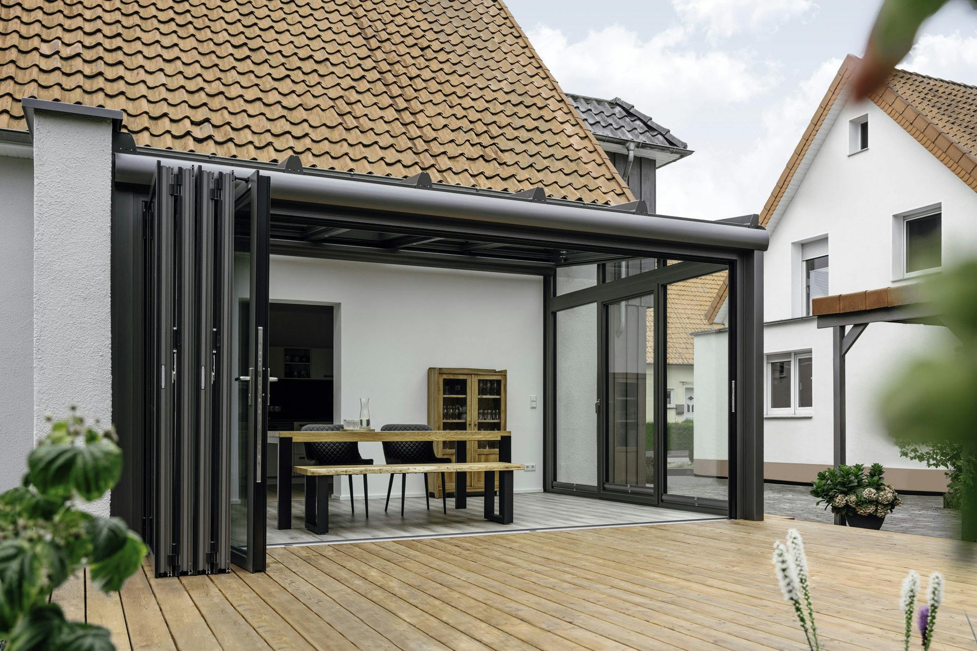 a glass orangery extension with open bifolding doors for indoor-outdoor living