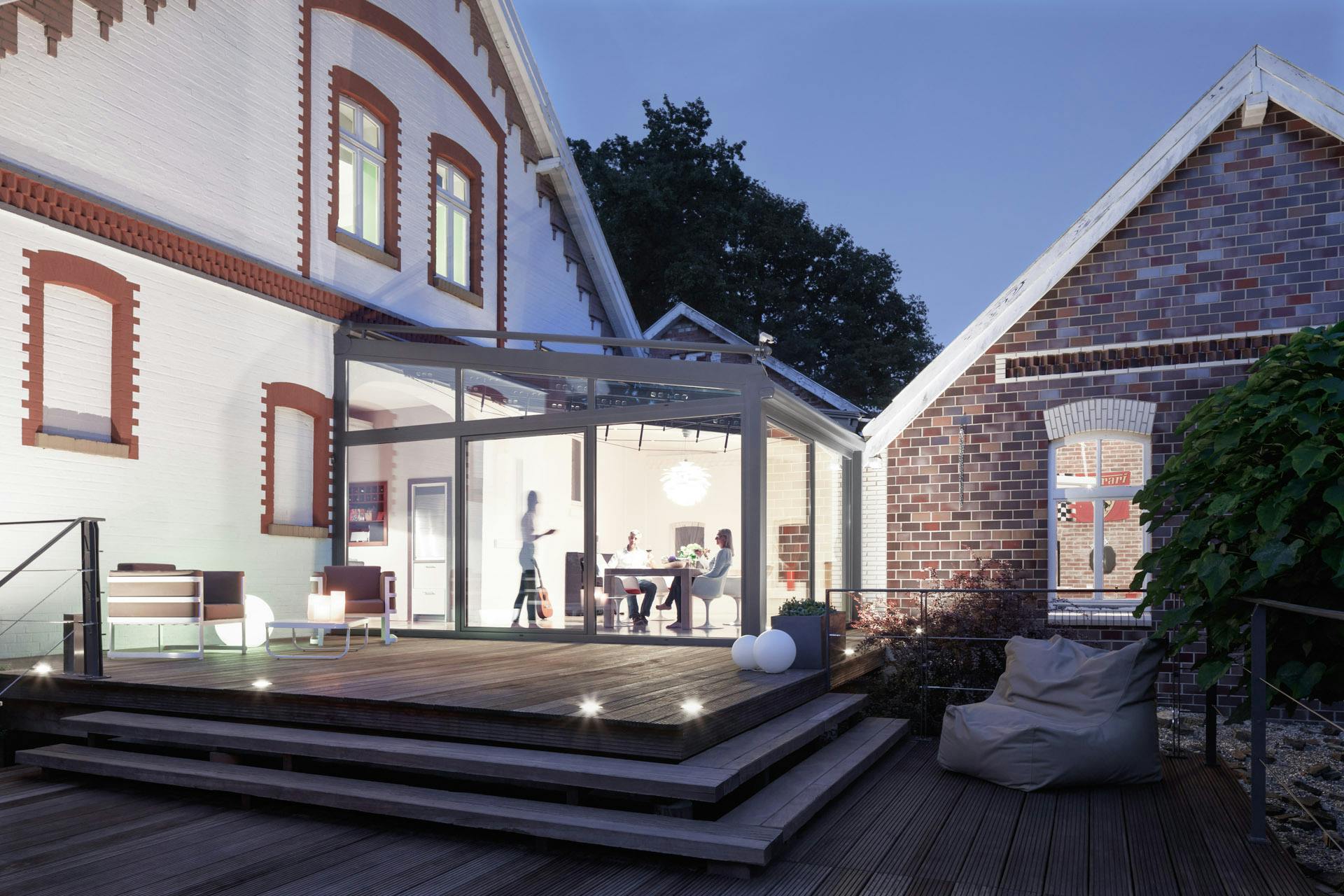 glass link extension between large white detached home and outbuilding