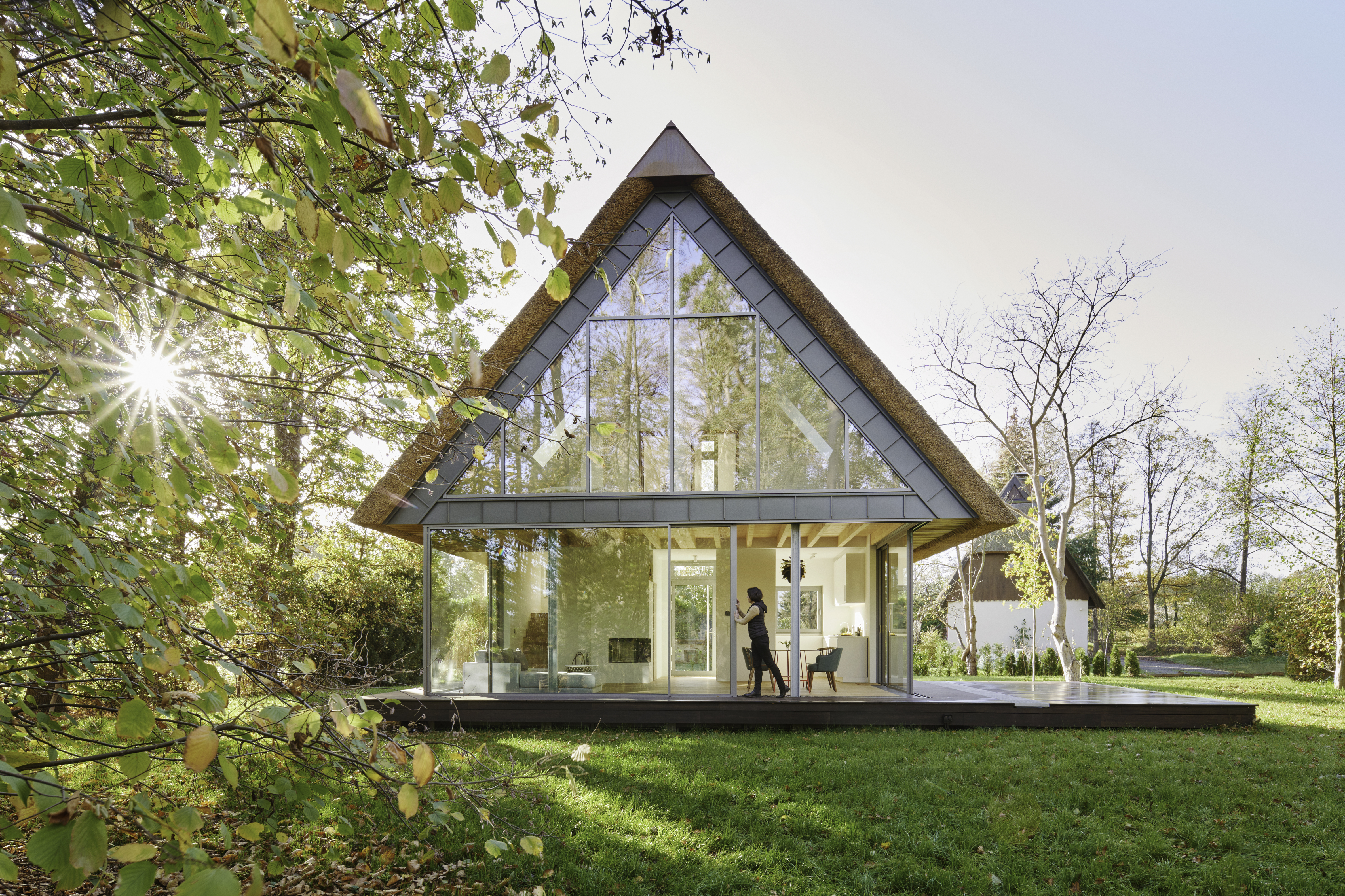 A silhouette of a woman opening a large sliding door