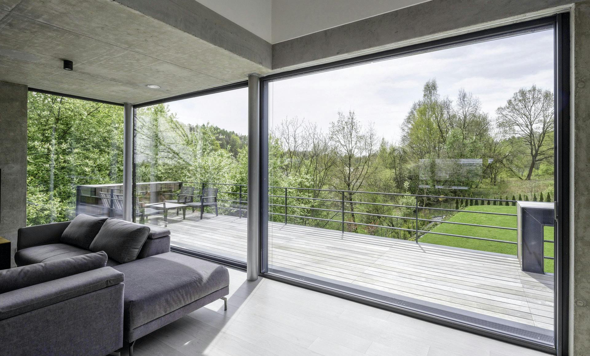 Large Solarlux sliding doors in living space with natural aesthetic and views of trees outside