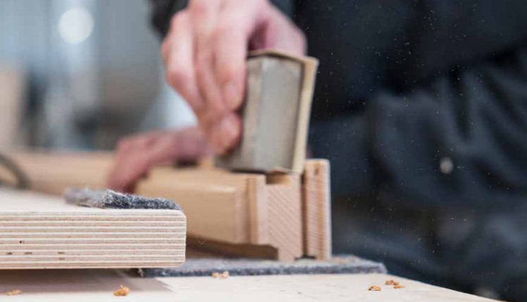 Workshop view of wood being sanded