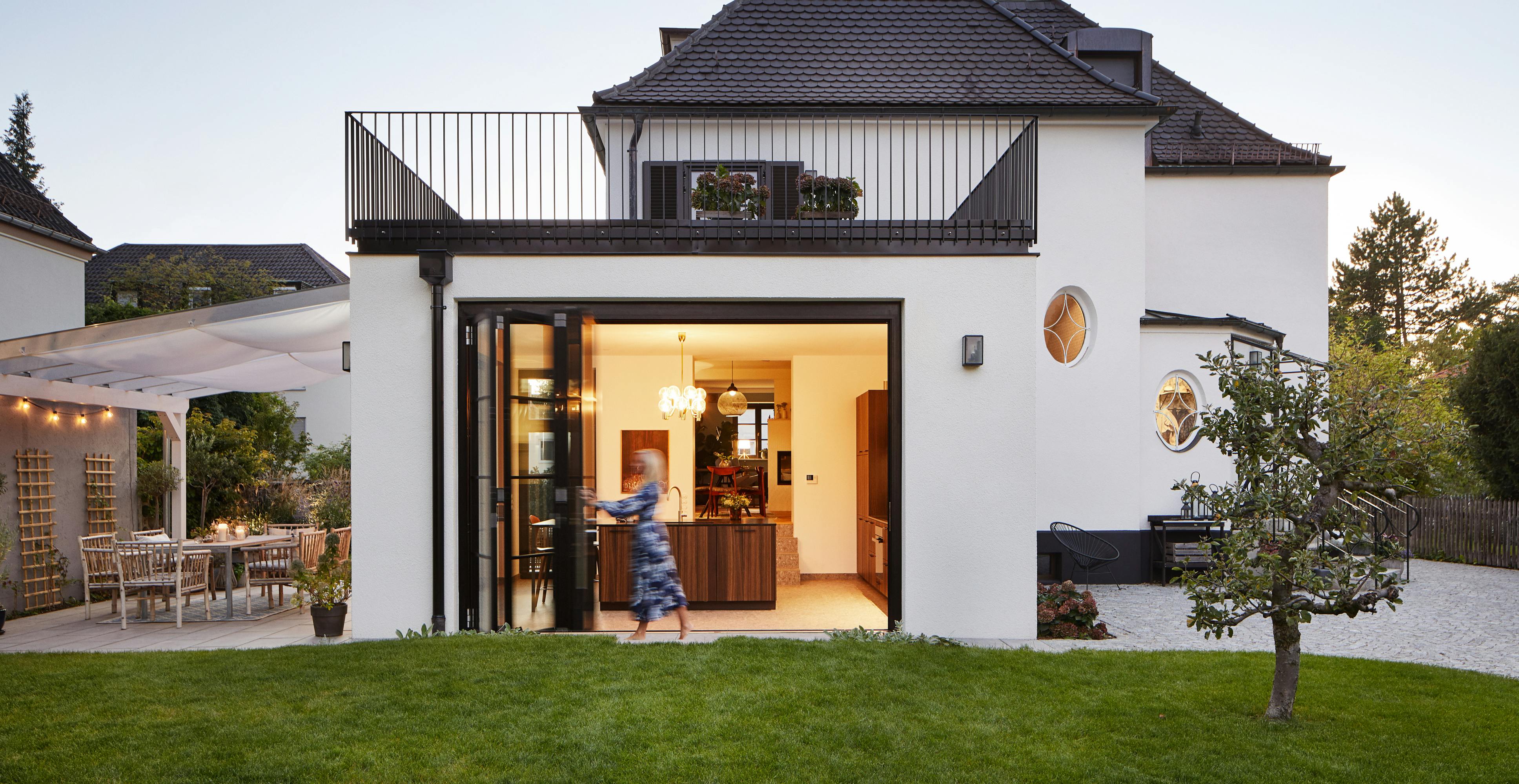A house and garden showing open bi-fold doors