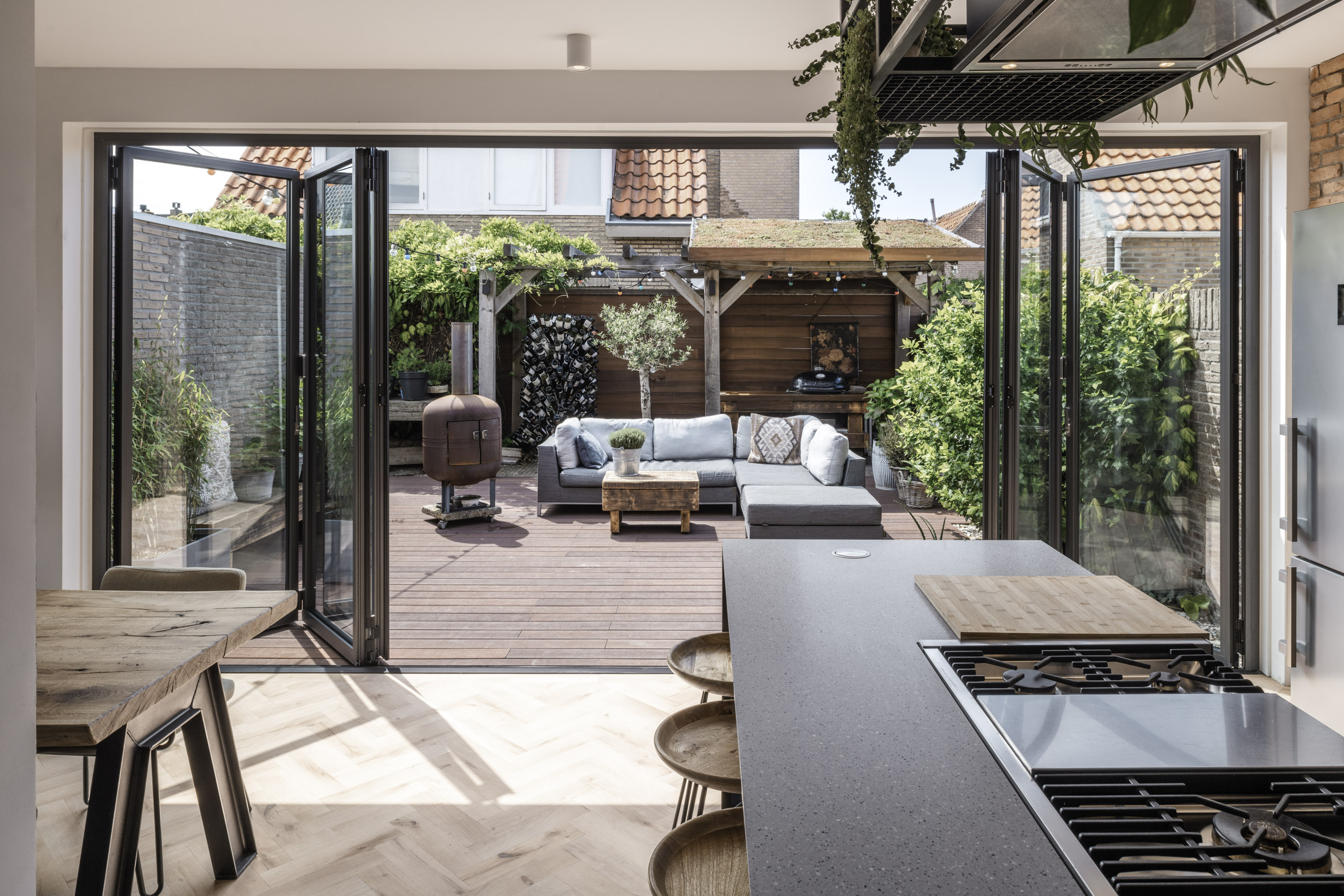 Open bi-fold doors leading to an outdoor seating area