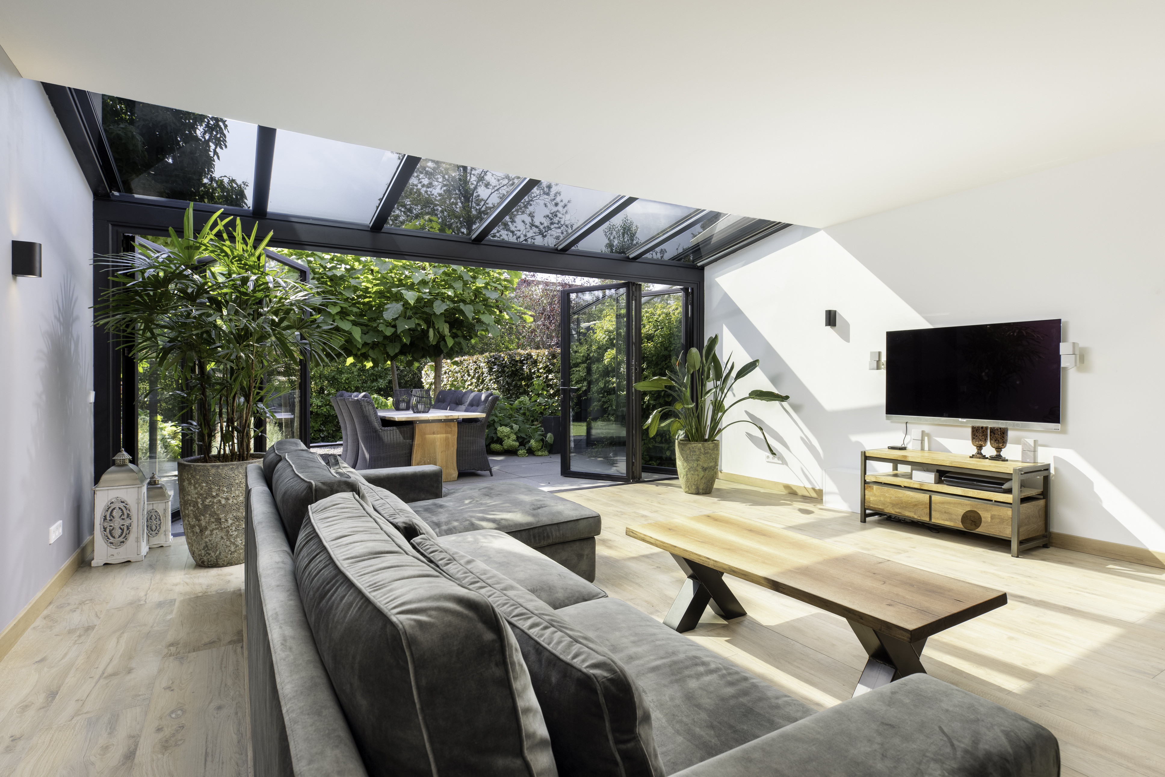 akzent plus wintergarden glass extension on a living room with sofas tables TV and cabinet