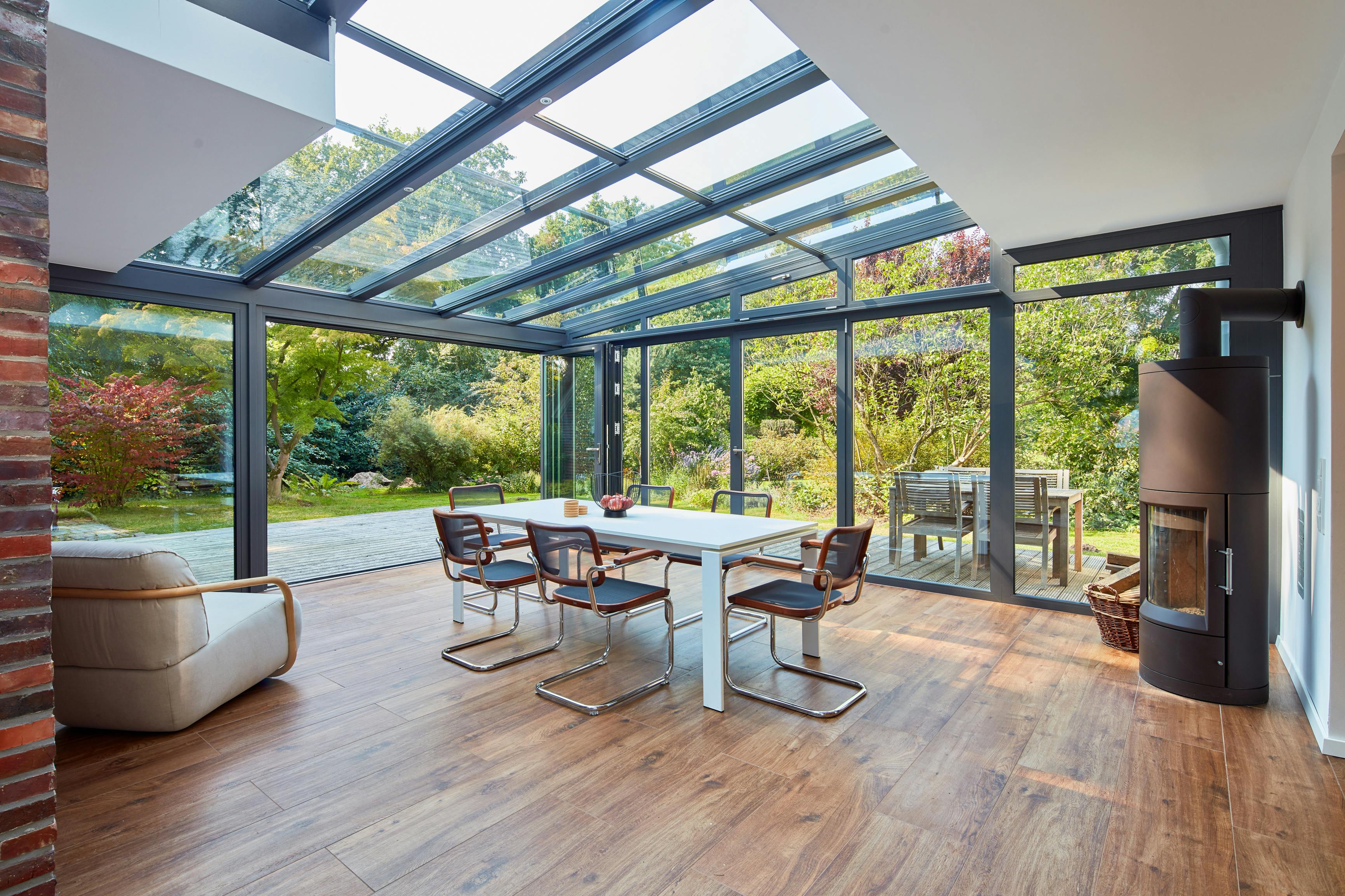 a light filled dining room with glass roof and sides