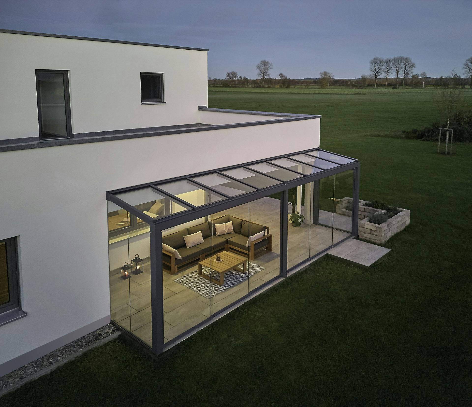 White box house with attached glass room at dusk