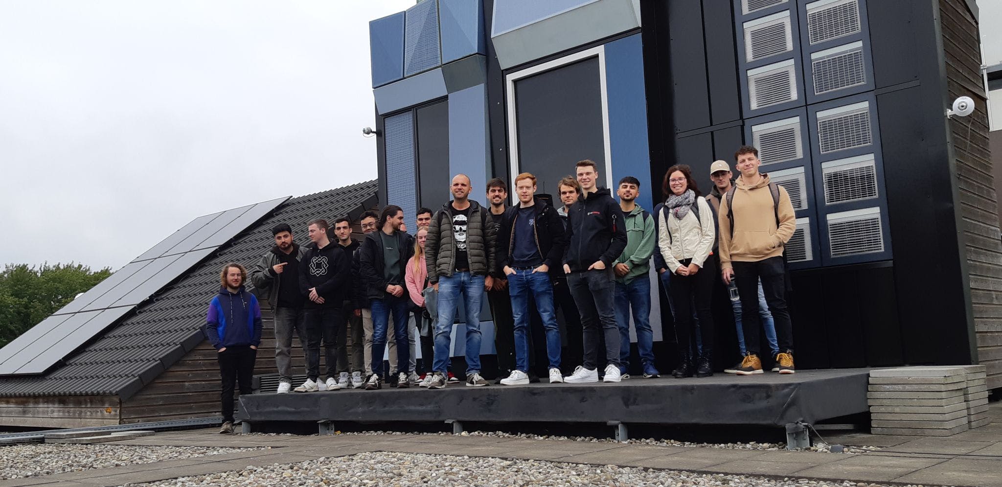 Group of students working on Solar Energy Technologies, standing in front of a Living Lab facility