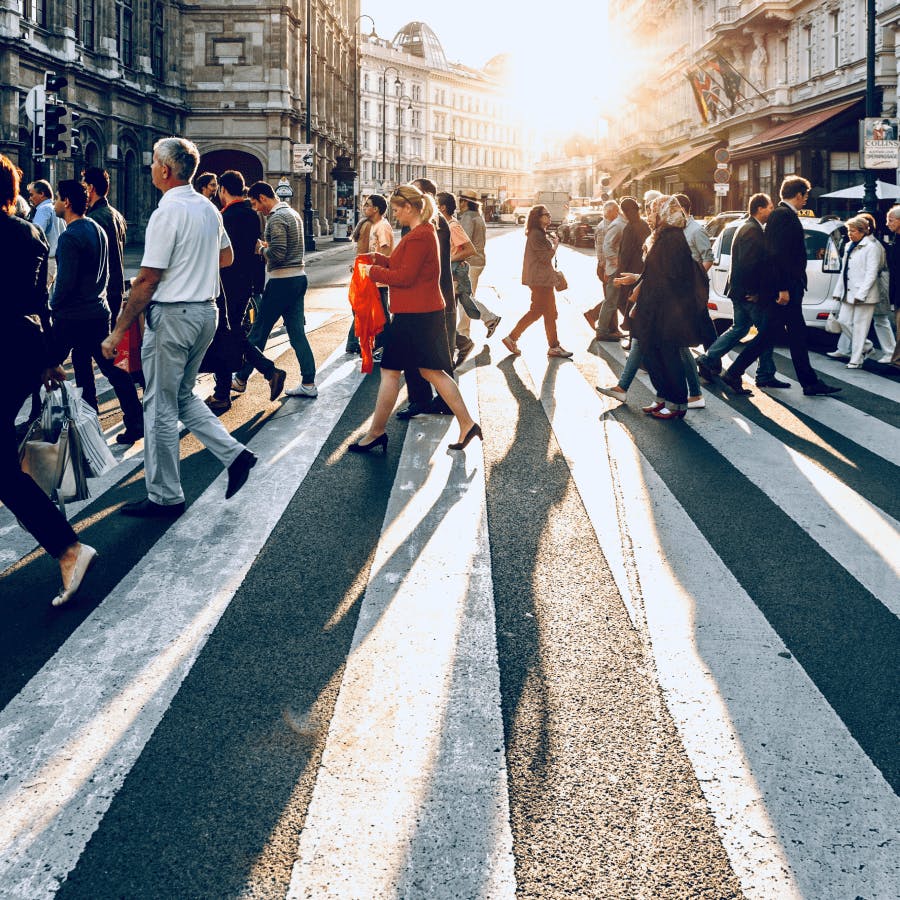 Multidão atrevessando a rua na faixa