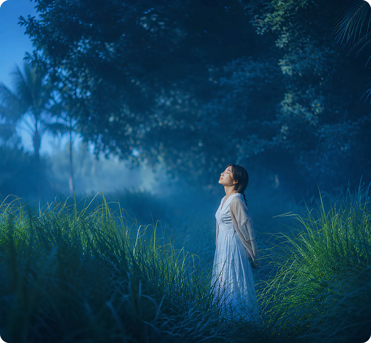 woman with eyes closed standing in a field