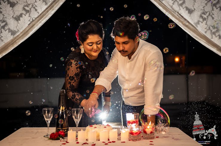 engagement couple poses with cake