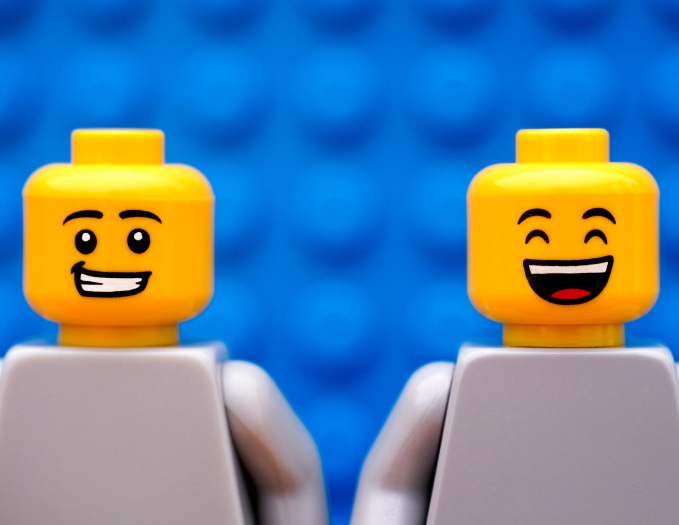 Two smiling LEGO characters in blue background