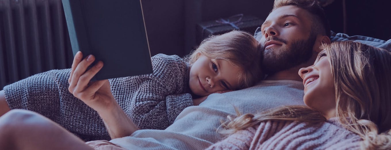 Perhe lukee kirjaa ja keskustelee taloudesta