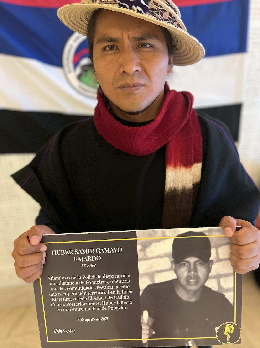 Lider Indigena Pedro Josse Velasco Tumiña aguantando un poster denunciando la muerte de Huber Samir Camayo.