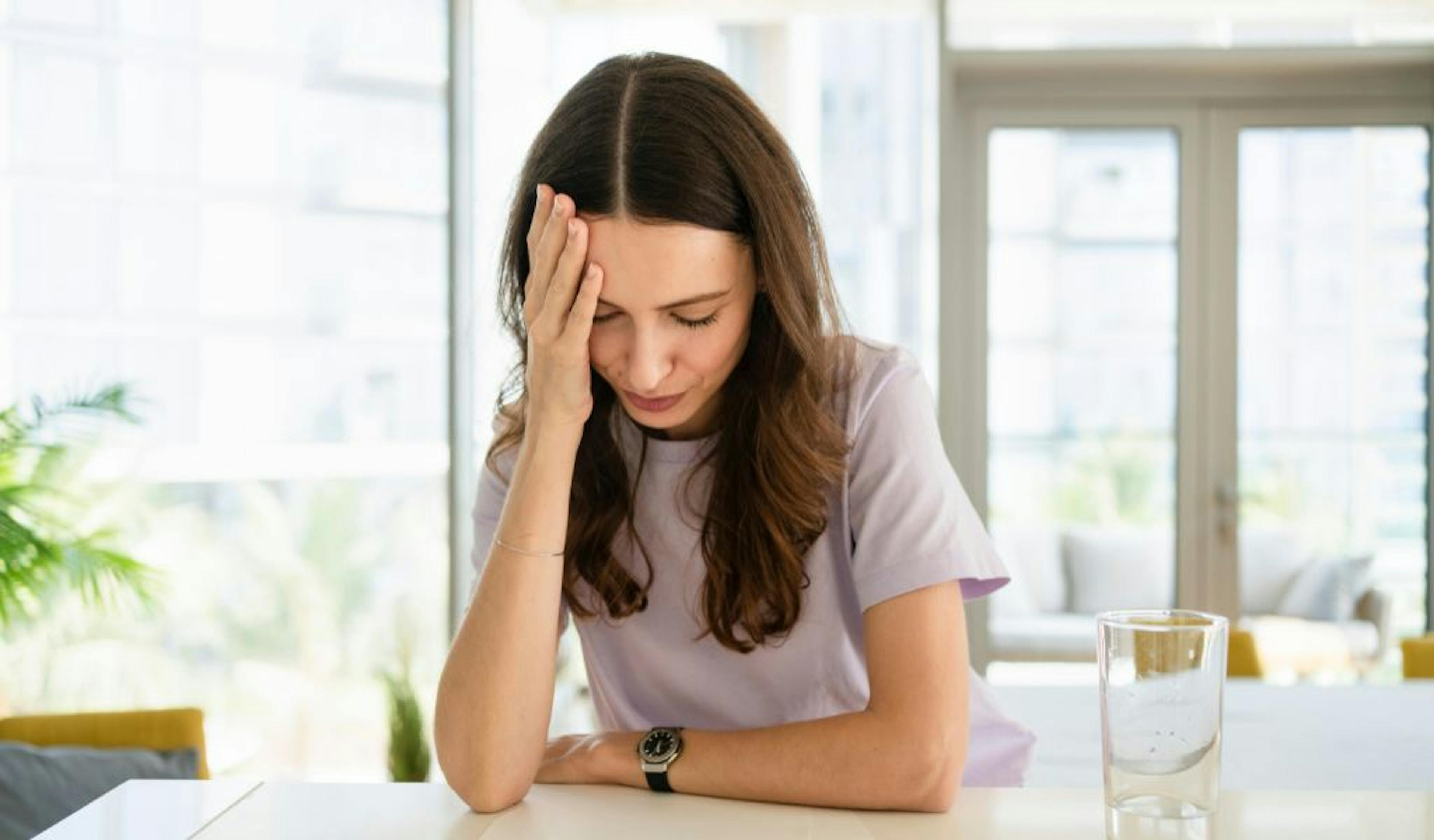 Mulher com mão no rosto estressada 