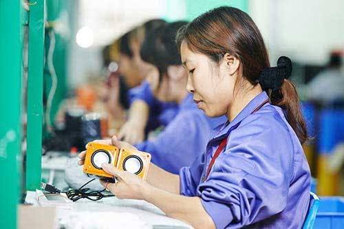 Factory worker assembling speakers